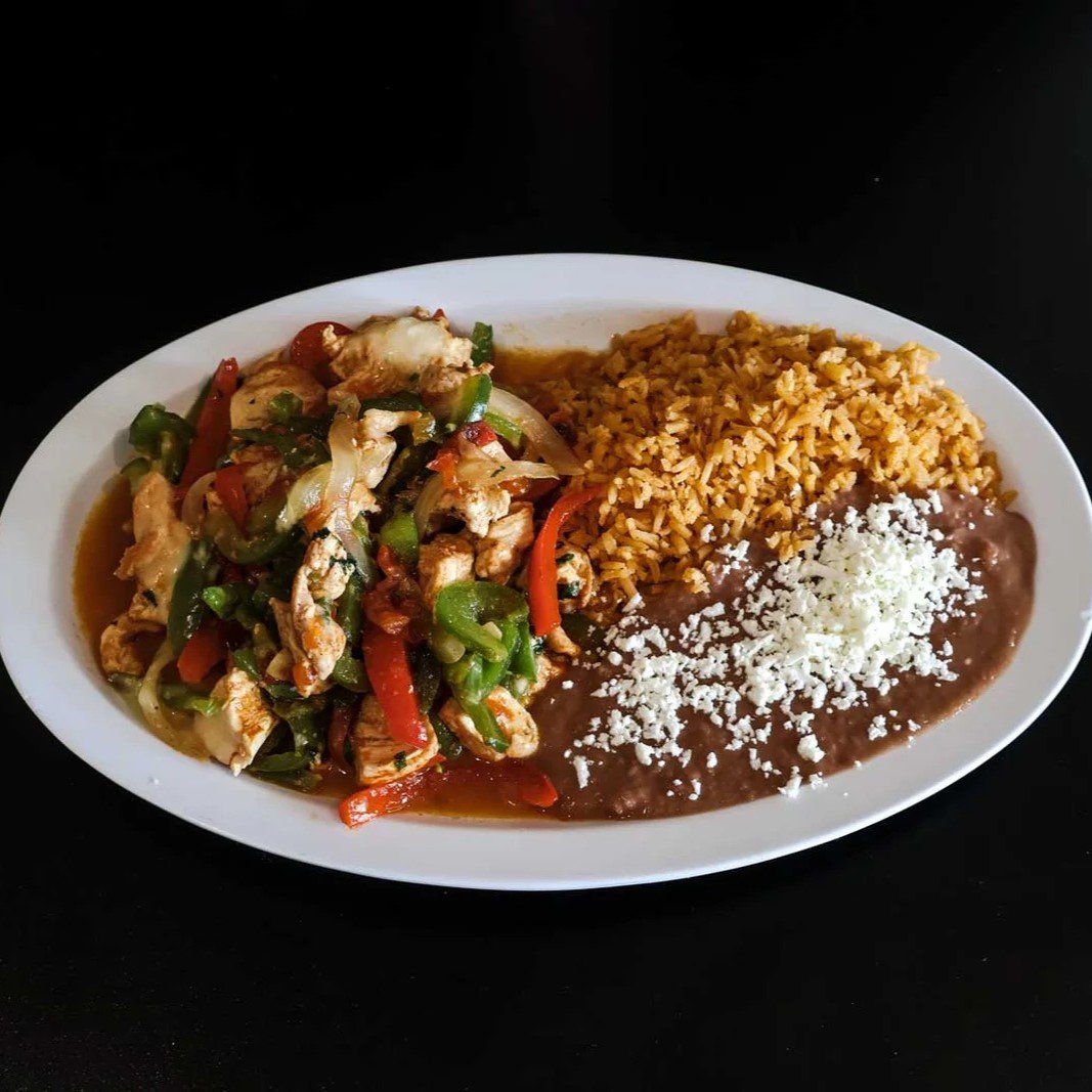 Chicken fajitas with rice and refried beans topped with cheese