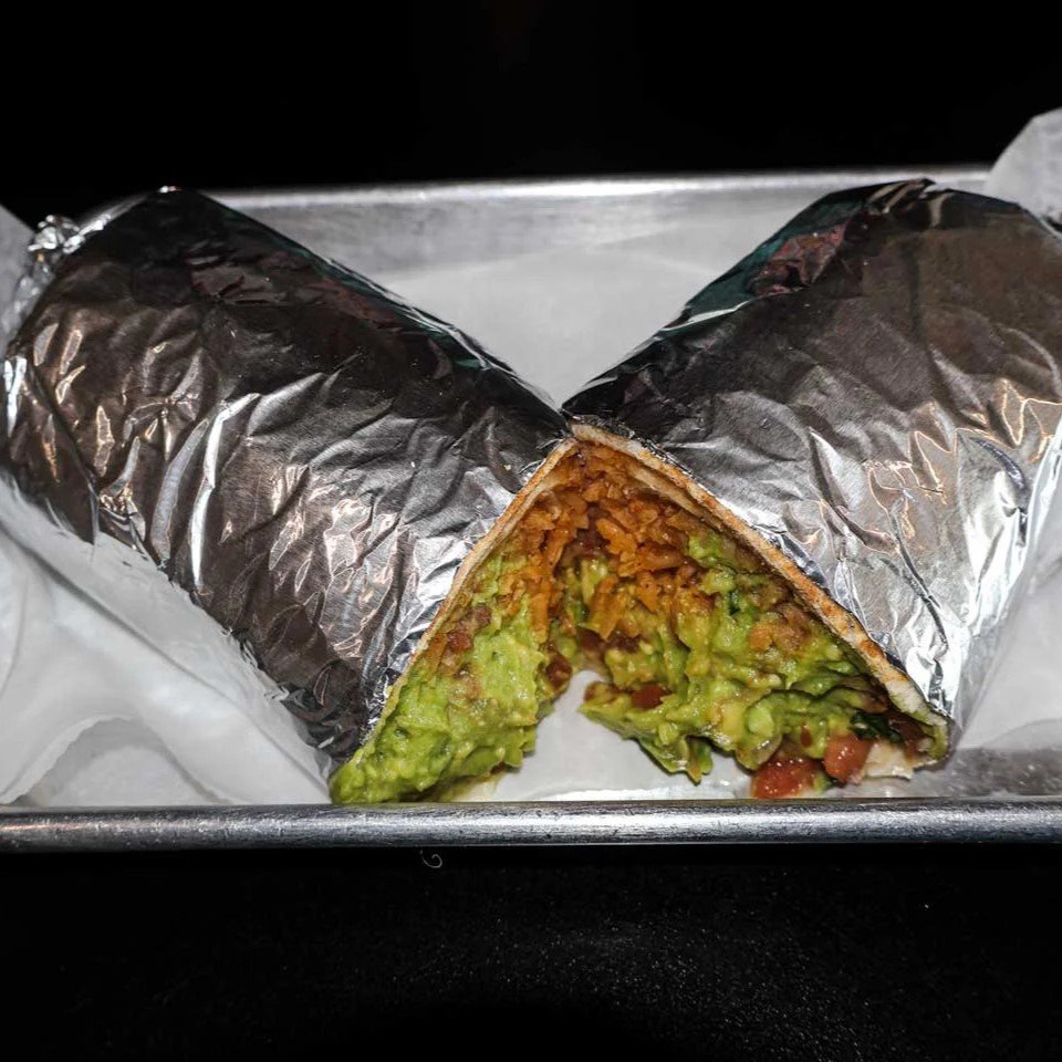 Mexican burrito with rice, beans, and guacamole wrapped in foil